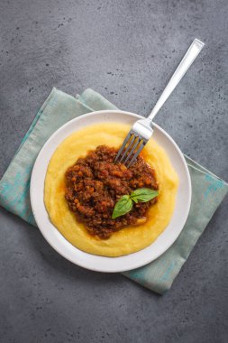 Etli soslu Polenta (haşlanmış mısır unu) - paçavra alla bolonez. Gri arka plan. Dikey resim.