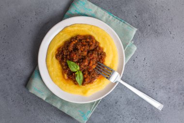 Etli soslu Polenta (haşlanmış mısır unu) - paçavra alla bolonez. Gri arkaplan. 