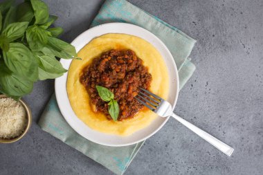 Etli soslu Polenta (haşlanmış mısır unu) - paçavra alla bolonez. Gri arkaplan. 