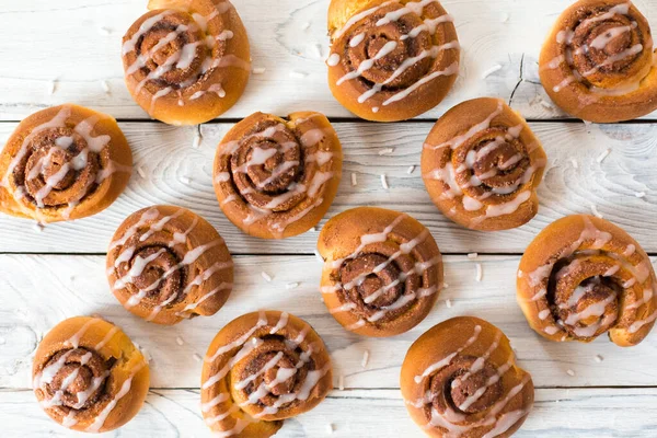 Beyaz arka planda kremalı ev yapımı tarçınlı çörekler..