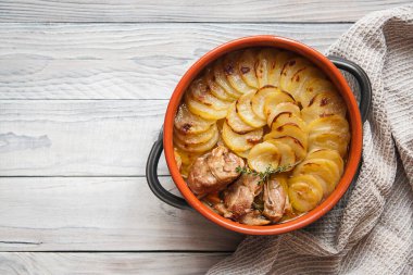 Hafif arka planda ev yapımı Lancashire güveci - kuzu, soğan, havuç, Worcestershire sosu, dilimlenmiş patates, körfez yaprağı, kekik ile kaplı ve düşük ısıda ağır bir tencerede pişirilmiş bir güveç..