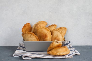 Ev yapımı Panzerotti. Güney İtalya usulü kızarmış cips. İçinde mozzarella ve mortadella var. Pamuk peçete. Işık arkaplanı, kopyalama alanı. Yatay resim.