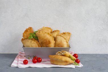 Ev yapımı Panzerotti. Güney İtalya usulü kızarmış cips. İçinde mozzarella, mortadella dolgu ve domates var. Işık arkaplanı, kopyalama alanı. Yatay resim.