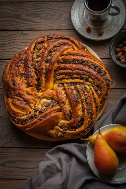 Mayalı kek Babka armut, çikolata ve fındıklı. Kahverengi ahşap. Dikey resim. 