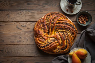 Mayalı kek Babka armut, çikolata ve fındıklı. Kahverengi ahşap. Boşluğu kopyala.