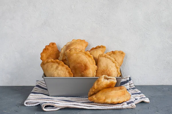 Homemade panzerotti - southern italian fried turnover. With mozzarella and mortadella filling. Cotton napkin. Light background, copy space. Horizontal image.