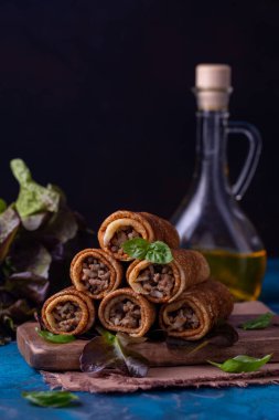 Kıyma, pilav ve kızarmış soğanla doldurulmuş gözleme ruloları. Karanlık arka plan. Dikey resim.