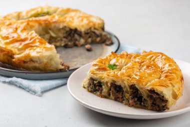 Yuvarlanan Burek, soslu turta, et ve mantar hissi. Sesam Seedes ile süslenmiş. Barış turtası. 