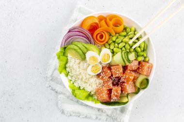 Somon balığı, pilav, avokado, kırmızı soğan, salatalık, edamame fasulyesi, havuç ve bıldırcın yumurtası, susamlı deniz ürünleri. Beyaz arkaplan. 