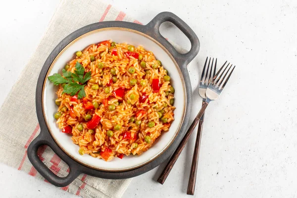 Djuvec pilavı - geleneksel Balkan yemeği. Pirinç, kırmızı dolma biber, domates, bezelye ve kırmızı biberle pişirilir. Işık arkaplanı, kopyalama alanı.