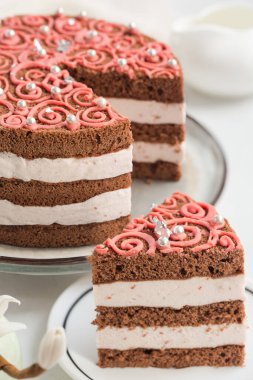 Kremalı ve ahududulu ev yapımı çikolatalı pasta, pembe süsleme. Ev yapımı. Yakın plan..