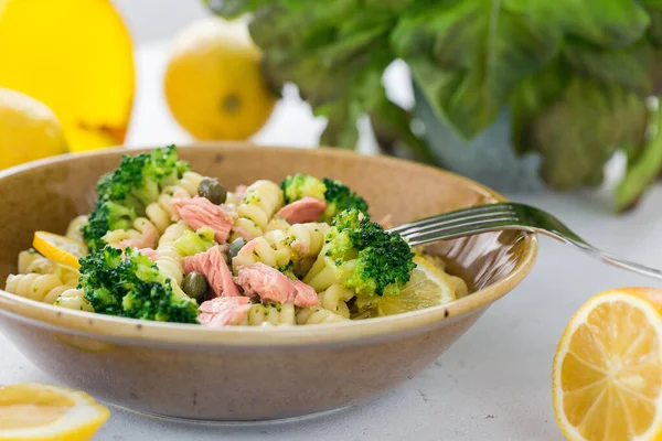 Plate with Apulian pasta fusilli with tuna fish, broccoli and lemon.