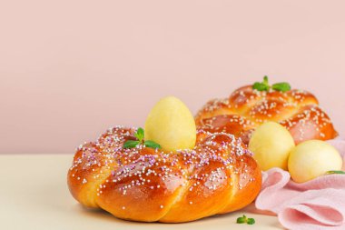 Mutlu Paskalyalar. Paskalya ekmeği ve şeftalili Paskalya yumurtaları ve naneli sarı arka plan. Boşluğu kopyala.