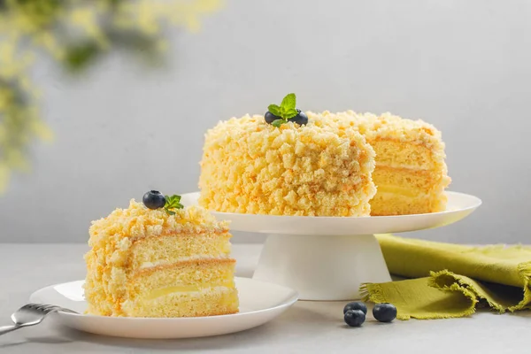 Uluslararası Kadınlar Günü kutlamaları için geleneksel İtalyan sünger keki. Mimosa pastası, yaban mersini ve nane ile süslenmiş..  