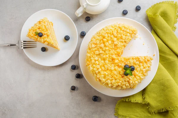 Top view of traditional italian Mimosa cake,  decorated with sponge cubes and crumbles, blueberries and mint. Horizontal image.