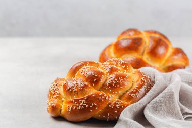 Susam tohumlu ev yapımı örgü ekmeği. Açık gri arkaplan, boşluğu kopyala.