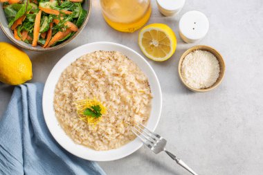 Akdeniz yemeği. Limon aromalı risotto, parmesan peyniri ve karabiber. Taze salata. Üst Manzara. Boşluğu kopyala.