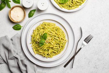 İtalyan yemeği - Trofie al pesto, fesleğen yaprağı soslu makarna, sert peynir, çam fıstığı, sarımsak, zeytinyağı. Işık arkaplan, üst görünüm.