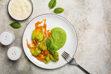 Kabak çiçeği ya da kabak çiçeği. Yumuşak peynirle doldurulmuş ve kremalı bezelyeyle servis edilmiş. Boşluğu kopyala