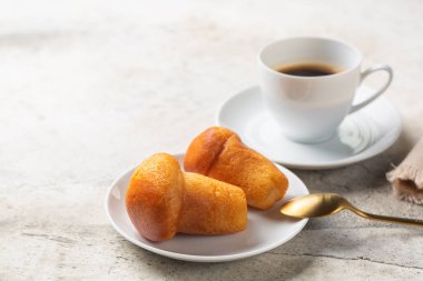 Rum baba and coffee espresso. Selective focus. Light background.