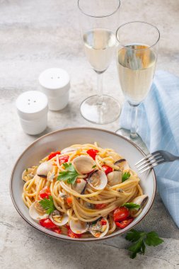 İtalyan yemeği, midyeli deniz ürünleri makarna ya da spagetti alle vongole ve beyaz şarap kadehleri. Işık taşı arkaplan, dikey resim.