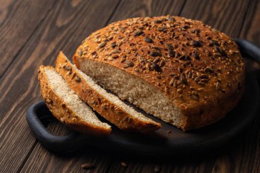 Tam buğday ekmeği ve farklı tohumlarla ev yapımı ekmek. Uzun mayalanmış, yavaş pişirilmiş. Sağlıklı ürün kavramı.