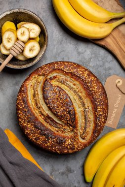 Ev yapımı muzlu ekmek ve fındık. Gri arkaplan, dikey resim.