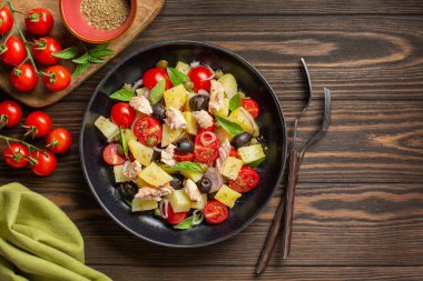 Pantesca salatası, Sicilya mutfağı. Haşlanmış patates, domates, soğan, kekik, kapari, siyah zeytin, uskumru gibi yağlı balık içerir. Koyu tahta arkaplan.