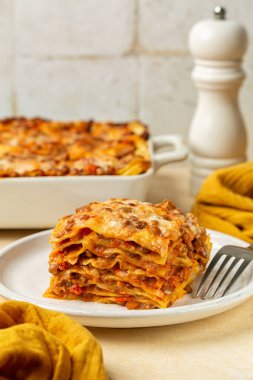 Ev yapımı Kırmızı Mercimek Lazanyası dilimini kapat. Vejetaryen yemeği, sebze, mercimek ve domates soslu katmanlı makarna ve üstüne krem peynir sosu. Dikey resim.