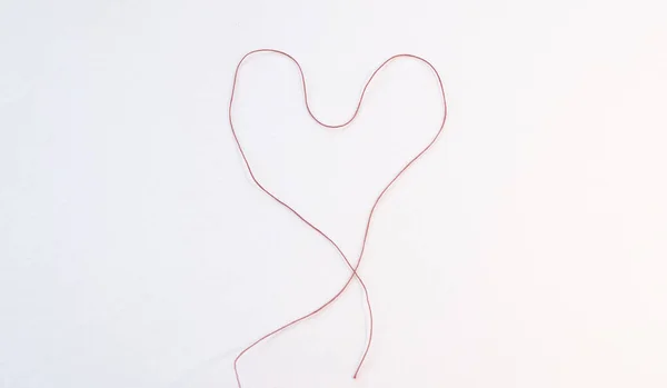 Beyaz arka planda bir kalp. Sevgililer Günü. Sevgi. İpliklerin kalbi. Sevgililer Günü. Kalpli bir kart. Sevgililer günü kartı.