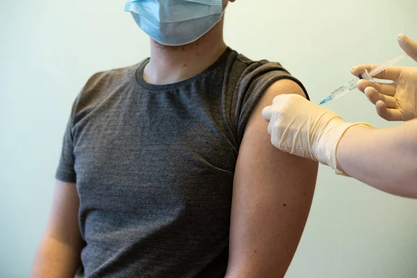 Doktorun elleri hastayı omzuna bağlıyor. maskeli hasta