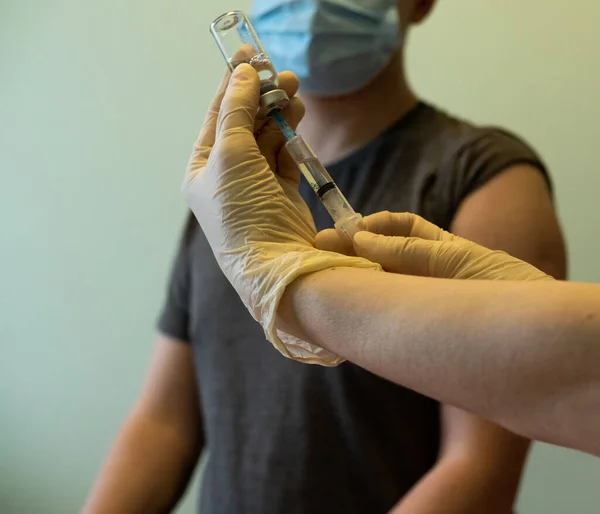 Enfeksiyon aşısı olan bir damar, şırınga ve maske. Aşı yapmak için bir doktor çantası..