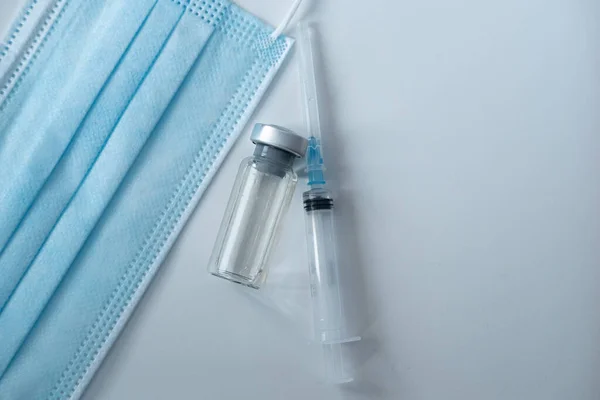 Enfeksiyon aşısı olan bir damar, şırınga ve maske. Aşı yapmak için bir doktor çantası..