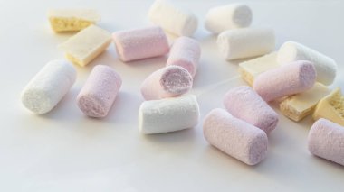 Açık arkaplanda beyaz çikolatalı pembe ve beyaz şekerlemeler.