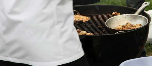 Aşçı sokakta balık eti ve ızgara mantar pişirir.