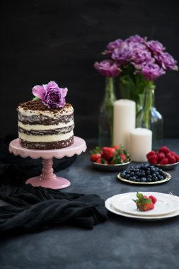 Çikolatalı kek, çilek, mumlar ve menekşe papağan laleler