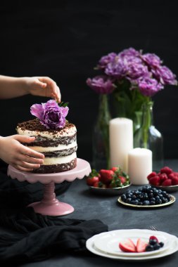 Çikolatalı kek, çilek, mumlar ve menekşe papağan laleler