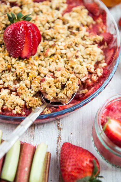 Rubarb and Strawberry crumble with all ingredients nearby — стоковое фото