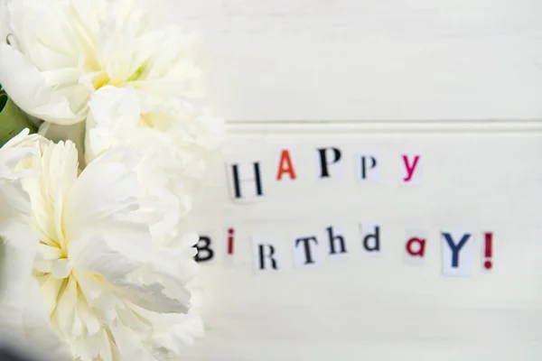 Gelukkige verjaardag brieven uitgesneden uit tijdschriften en witte pioenrozen — Stockfoto