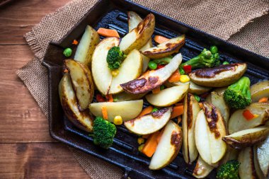 Demir döküm Pan sebzeli patates dilimleri