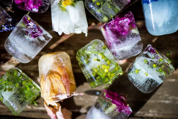 Donmuş buz küpleri rustik ahşap zemin üzerine çiçeklenir