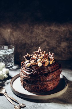 Çikolata kaplamalı üç katlı küçük çikolatalı pasta.