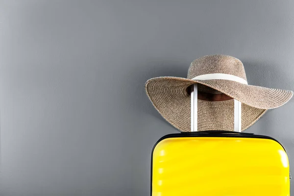 Maleta de tamaño cabina con sombrero de paja —  Fotos de Stock