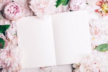 Pembe şakayık çiçeklerinden yapılmış çerçeve ve açık bir defter