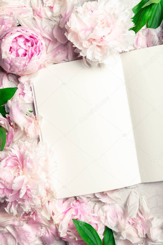 Frame made of pink peony flowers and open notebook