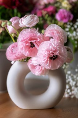 Seramik vazoda narin ranunculus çiçekleri