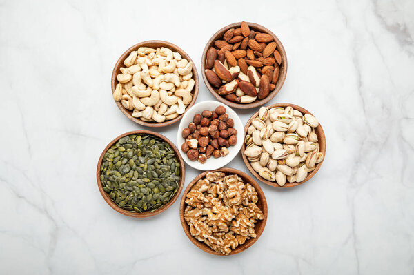 Different kind of nuts in wooden bowls