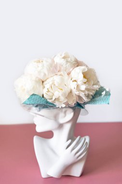 İnsan kafası vazosundaki beyaz şakayıklar.