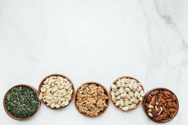 Different kind of nuts in wooden bowls