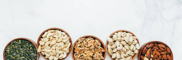 Different kind of nuts in wooden bowls